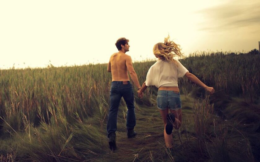 Cuplu care aleargă într-un lan de grâu