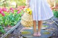 Femeie desculță într-o gradină cu flori