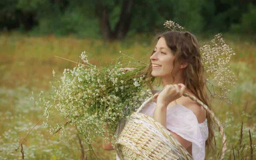 Femeie care zâmbește și are un buchet de flori în mână