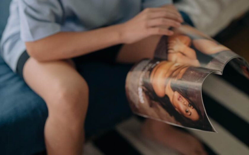 Bărbat se uită într-o revistă cu femei
