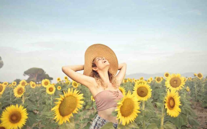 Femeie fericită într-un lan de floarea soarelui